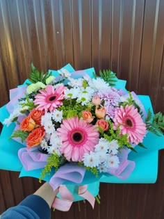 a person holding a bouquet of colorful flowers