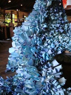 a large pile of blue paper sitting on top of a wooden floor