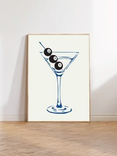 an art print of a martini with olives on the rim in blue and white