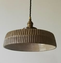 a light hanging from a ceiling in a room with white walls and a black cord