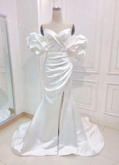 a white wedding dress on display in front of a mirror