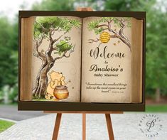 an open book with winnie the pooh and honey on it sitting on top of a wooden easel