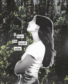 a woman standing in front of some trees with words on it that say forget you aren't mine