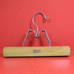 a pair of metal hooks hang on a red surface