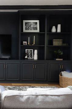 a living room filled with furniture and a flat screen tv on top of a wooden entertainment center