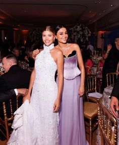 two women standing next to each other at a formal event