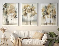 three paintings hang on the wall above a couch in a room with white furniture and potted plants