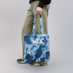 Blue tie-dye tote bag is made from 100% organic cotton fabric. The material is thicker that standard tote bags' and the stap is long enough to put over the shoulder. This tote bag will be perfect for grocery shopping or just caring your goods, books while walking around town, beach. Each and every bag is individually tie dyed by hand, prints may slightly differ from the image, which makes every hat completely unique! The tote bags are also dyed with vegan biodegradable dyes. FEATURES * Made of 1 Bohemian Cotton Canvas Bag For Daily Use, Casual Tie Dye Cotton Bag, Everyday Blue Cotton Beach Bag, Indigo Cotton Bag For Everyday Use, Eco-friendly Blue Cotton Beach Bag, Everyday Indigo Cotton Bag, Blue Cotton Tote Beach Bag, Handmade Cotton Beach Bag For Daily Use, Blue Cotton Tote Shoulder Bag