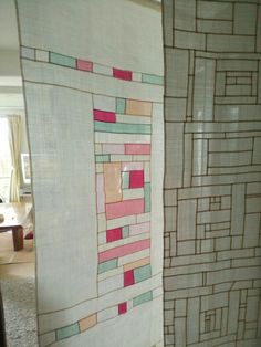 a bathroom with a shower curtain that has different colored blocks on it and a toilet in the background