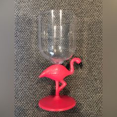 a pink flamingo wine glass holder on a black and white patterned wallpaper background