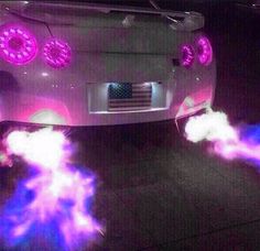 the front end of a white car with purple and blue lights