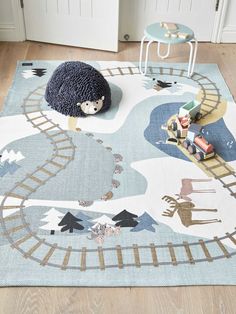 a child's play area with toy train tracks and animals on the rugs