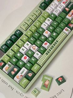 a green and white computer keyboard sitting on top of a table next to stickers