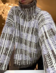 a woman wearing a gray and white sweater