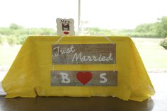 a table with a sign that says trust married boys on it and a red heart in the middle