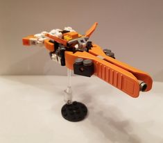 an orange and black lego model on a white surface