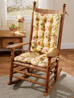 a wooden rocking chair with floral cushions