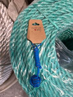 a spool of blue and white twine with a tag on it sitting next to some wire