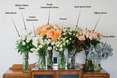 several vases filled with flowers sitting on top of a wooden table