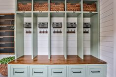 an organized mud room with baskets on the wall and drawers in front of it,