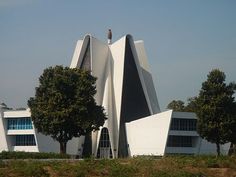 an unusual building with trees in front of it