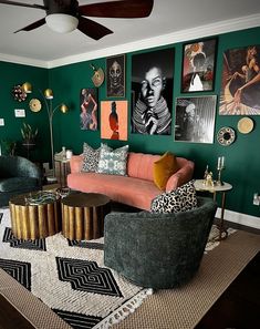 a living room with green walls and pictures on the wall above the couch, coffee table