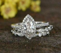 a close up of a ring on top of a table with flowers in the background