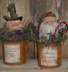 two tin canisters with christmas decorations in them