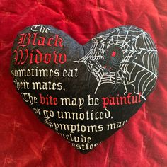 a black heart with words written on it sitting on a red cloth covered tablecloth