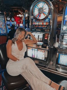 a woman sitting on top of a chair next to slot machines