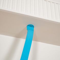 a blue tie hanging from the side of a white wall