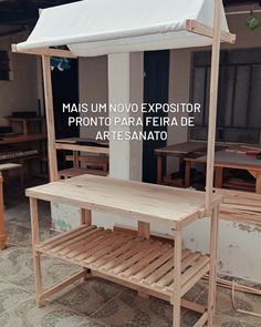 a wooden bench sitting in front of a white awning on top of a building