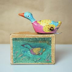 a colorful bird figurine sitting on top of a box