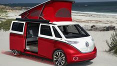 a red and white camper van parked on top of a sandy beach next to the ocean