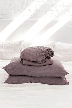 three pillows stacked on top of each other on a bed