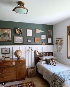 a bed room with a neatly made bed and lots of pictures on the wall above it