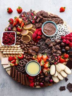 a platter filled with chocolate, strawberries, cookies, and other foodstuffs