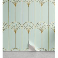 an art deco wallpaper with gold lines and fan shapes on it, against a mint green background