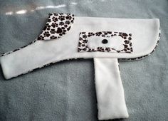 a white and brown animal print scarf on top of a bed