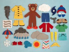 a group of cut out toys sitting on top of a blue surface with clouds and umbrellas