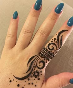 a woman's hand with a black and white henna tattoo design on it