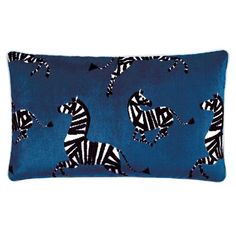 a blue pillow with zebras on it and black triangles in the middle, against a dark blue background