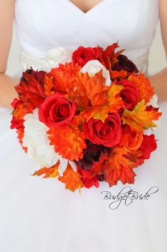 a bride holding a bouquet of red and orange flowers