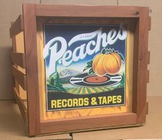 there is a sign that says peaches records and tapes on the side of a wooden box