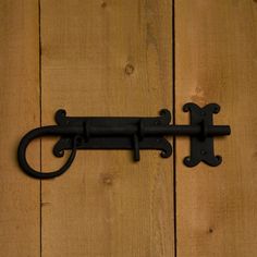 an iron door handle on a wooden wall