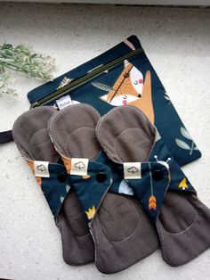 four oven mitts sitting on top of a counter next to a potted plant