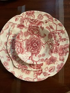 three red and white plates sitting on top of a wooden table