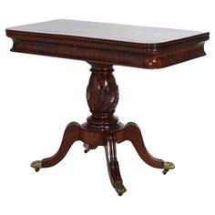 a wooden table with an ornate design on the top and legs, sitting against a white background