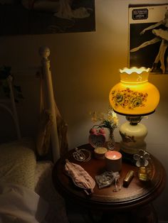 a yellow lamp sitting on top of a table next to a vase and other items