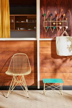 two chairs and a table in front of a wall with wood paneled panels on it